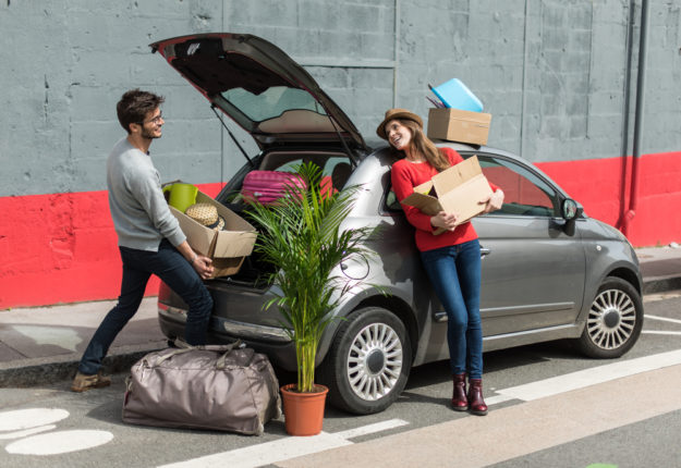 Young,Couple,Moving,House,,Holding,Moving,Boxes,Beside,Their,Car